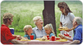 Photo of a family of seven gathered around a picnic table